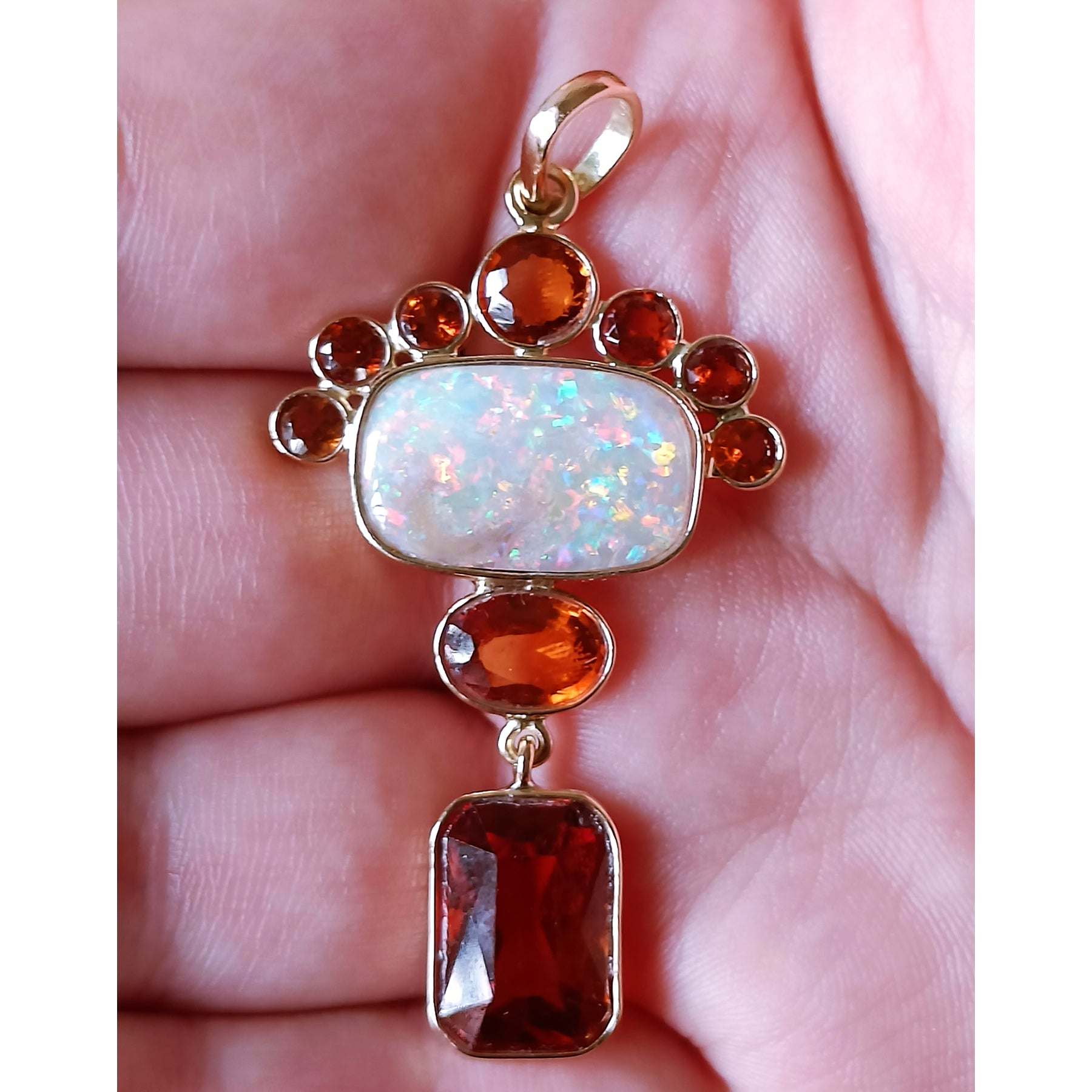on palm view of Aurora Empress Pendant handcrafted in gold